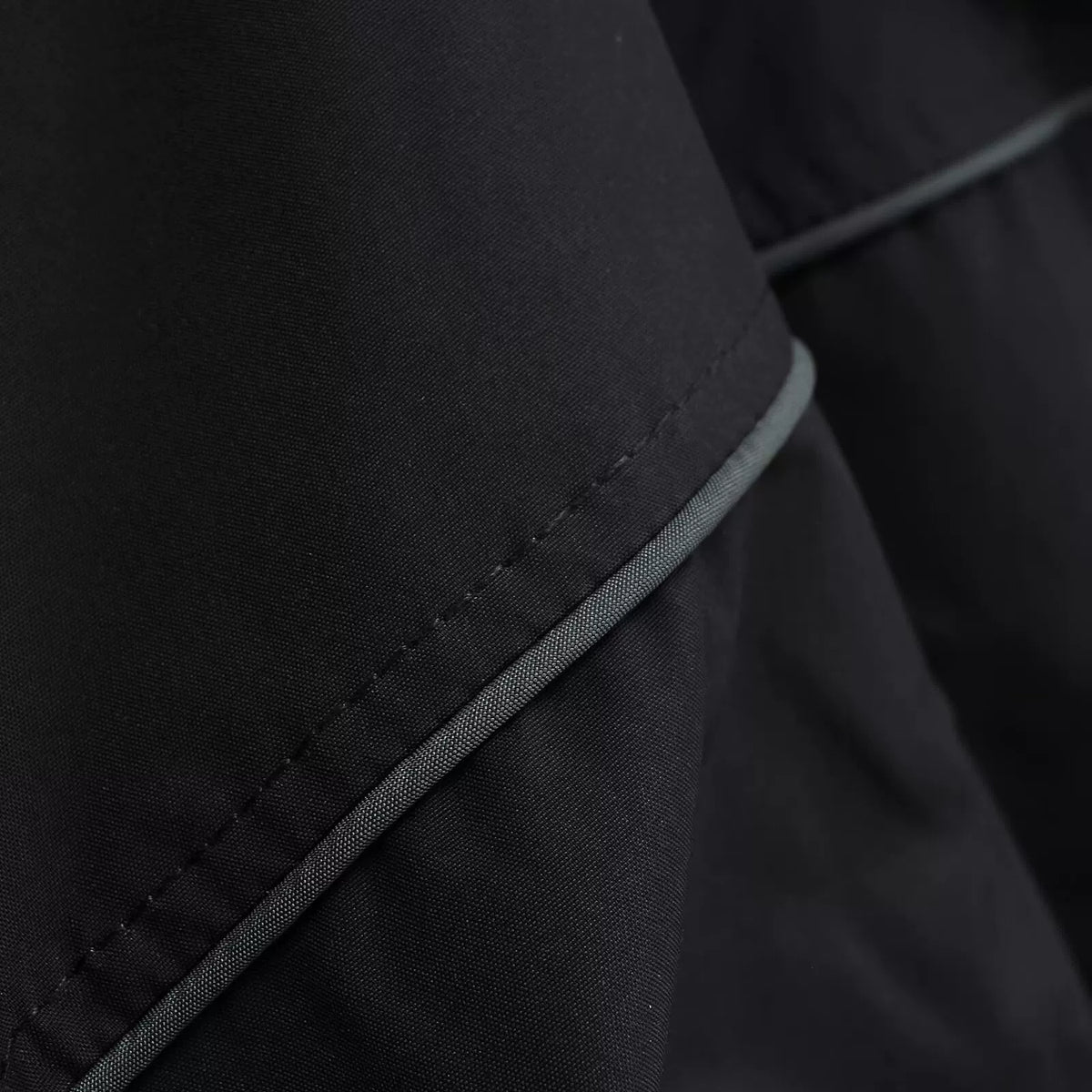 Contrast grey piping on the sleeve seam, close-up